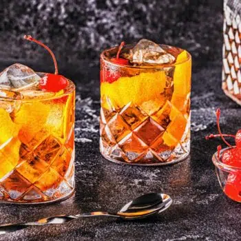 Old Fashioned Cocktail With Cherries And Orange Twist.